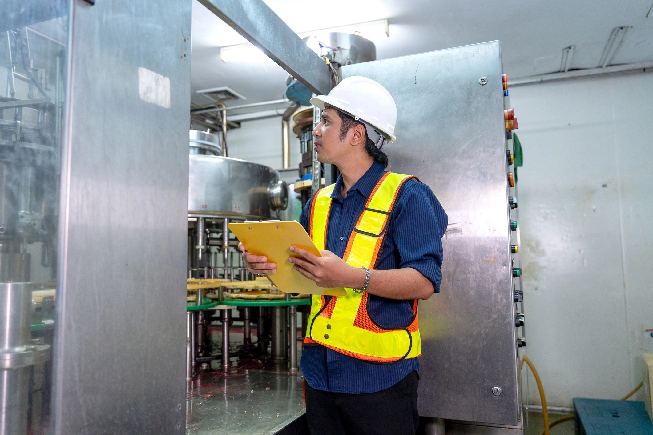 Industrial inspection professional reviewing equipment in a plant environment